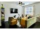 Bright living room features a decorative ceiling fan, modern furniture, and a large window at 1606 Larkspur Trl, Conyers, GA 30012