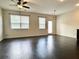 Open living space with dark hardwood floors, natural light, and access to a balcony or patio at 1606 Larkspur Trl, Conyers, GA 30012