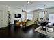 Bright living room with dark hardwood floors, modern decor, and a dining area with stylish furniture at 1606 Larkspur Trl, Conyers, GA 30012