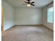 Spacious main bedroom with neutral carpeting, a ceiling fan, and a window with blinds at 1606 Larkspur Trl, Conyers, GA 30012