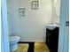 Powder room featuring a toilet, vanity with cabinet storage, and decorative framed art at 1606 Larkspur Trl, Conyers, GA 30012