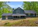 View of the backyard featuring mature trees and a large back porch at 5200 Beechwood Forest Ct, Lithonia, GA 30038