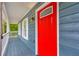 View of covered porch with a bright red front door with upper glass detailing and modern light fixture at 5200 Beechwood Forest Ct, Lithonia, GA 30038