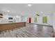 Open-concept living room with a modern kitchen featuring white cabinets, an island, recessed lights, and gray wood floors at 5200 Beechwood Forest Ct, Lithonia, GA 30038