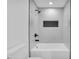 White tiled shower featuring black fixtures and an integrated storage niche at 5200 Beechwood Forest Ct, Lithonia, GA 30038
