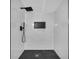 Modern shower with black hardware, tile accent and herringbone shower floor at 5200 Beechwood Forest Ct, Lithonia, GA 30038