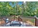 Cozy back porch featuring an outdoor rug and wicker chairs, with a view of the expansive green backyard at 54 Mildred Ct, Dallas, GA 30157