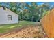 Home's backyard features a newly built wooden fence, a mix of grassy and natural areas, and a view of the home at 54 Mildred Ct, Dallas, GA 30157