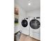 Convenient laundry room with modern, front-load washer and dryer, as well as storage space and a light wood floor at 405 Newland Way, Acworth, GA 30102