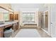 Well-lit bathroom with a soaking tub, shower, vanity with ample counter space, and a large window with natural light at 6069 Queens River Dr, Mableton, GA 30126