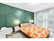 Bedroom with stylish green accent wall, ample natural light, and modern decor at 6069 Queens River Dr, Mableton, GA 30126