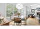 Bright breakfast nook with large windows, round table, view to living room, and comfortable green chairs at 6069 Queens River Dr, Mableton, GA 30126