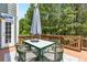 Outdoor deck area with table, chairs, and an umbrella, perfect for entertaining at 6069 Queens River Dr, Mableton, GA 30126