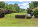 Fully fenced community dog park with greenery, benches and clear signage for park rules at 6069 Queens River Dr, Mableton, GA 30126