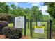 Fenced community dog park with rules sign and shady trees for residents at 6069 Queens River Dr, Mableton, GA 30126
