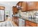 A well-lit kitchen featuring wood cabinetry, stainless appliances, and a view of the dining area at 6069 Queens River Dr, Mableton, GA 30126