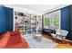 Stylish living room with a wall of built-in bookshelves, piano, rocking chair and comfortable orange couch at 6069 Queens River Dr, Mableton, GA 30126