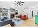 Bright living room featuring a cozy fireplace, a ceiling fan, and comfortable seating at 6069 Queens River Dr, Mableton, GA 30126