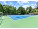 Community tennis courts with a green and blue surface, surrounded by lush trees at 6069 Queens River Dr, Mableton, GA 30126