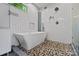 Modern bathroom featuring pebble stone floor, white cabinets, and soaking tub at 670 Parker Ave, Decatur, GA 30032