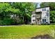 Two-story home featuring a manicured lawn, balconies, and a lush green tree line at 670 Parker Ave, Decatur, GA 30032