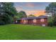 Backyard of a red brick home with a lush lawn and a covered back porch at 1091 Pine St, Conyers, GA 30012