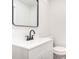 Bright, modern bathroom with white cabinets, dark hardware, and a large vanity mirror at 1091 Pine St, Conyers, GA 30012