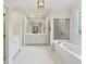 Bright bathroom with white cabinets, a large mirror, a soaking tub and a shower at 3499 Paces Ferry Se Cir, Smyrna, GA 30080