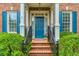 Close-up of a blue front door framed by white columns, brick steps, and manicured greenery at 3499 Paces Ferry Se Cir, Smyrna, GA 30080