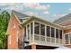 Exterior view of a brick house with a screened porch and spiral staircase at 3499 Paces Ferry Se Cir, Smyrna, GA 30080