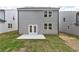 New home backyard featuring a concrete patio, grass, gray siding, and double doors at 407 Newland Way, Acworth, GA 30102