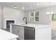 Open concept kitchen features a stainless steel dishwasher and view of the fireplace at 407 Newland Way, Acworth, GA 30102