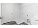 New home laundry room featuring gray vinyl flooring, storage shelving, utility sink, and door at 407 Newland Way, Acworth, GA 30102