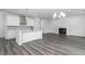 Open-concept living space featuring modern kitchen, fireplace, and wood-look flooring at 407 Newland Way, Acworth, GA 30102