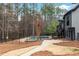 Backyard with the fence-enclosed pool, stairs to the second-story deck and a wooded backdrop at 1066 Fairway Valley Dr, Woodstock, GA 30189