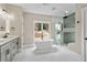 Spacious bathroom with white marble floors, a soaking tub and a glass enclosed shower at 1066 Fairway Valley Dr, Woodstock, GA 30189