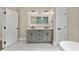 Bathroom with double vanity, gray cabinets, marble countertop and decorative light fixtures at 1066 Fairway Valley Dr, Woodstock, GA 30189