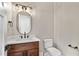Stylish half bathroom with wood vanity, stone countertop, modern lighting, and black fixtures at 1066 Fairway Valley Dr, Woodstock, GA 30189
