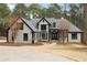 Stunning two-story home featuring a manicured lawn and inviting entryway with classic gray and black design elements at 1066 Fairway Valley Dr, Woodstock, GA 30189