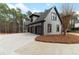 Stylish grey home featuring a 4-car garage, dark trim, and professional landscaping at 1066 Fairway Valley Dr, Woodstock, GA 30189