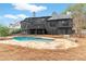 Elegant home with a stone patio surrounding the pool and a multi-level deck at 1066 Fairway Valley Dr, Woodstock, GA 30189