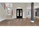Elegant foyer with hardwood floors, staircase with wood and iron railings, and stylish black double doors at 1066 Fairway Valley Dr, Woodstock, GA 30189