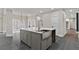 Kitchen island with quartz countertop, stainless sink, and stylish faucet with gray cabinets and stone flooring at 1066 Fairway Valley Dr, Woodstock, GA 30189