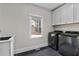Functional laundry room with sink, gray cabinets, and modern washer and dryer set at 1066 Fairway Valley Dr, Woodstock, GA 30189