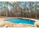 Modern in-ground pool with stone tile, water feature, and fully fenced backyard at 1066 Fairway Valley Dr, Woodstock, GA 30189