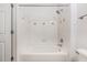 Bright bathroom features a tub with shower head and decorative diamond tile accents at 1850 Cotillion Dr # 4218, Atlanta, GA 30338