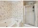 Bathroom featuring a soaking tub with shower, floral wallpaper, and tiled floors at 4856 Saddlerun Ln, Powder Springs, GA 30127