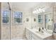 Bright bathroom with double sinks, floral wallpaper, decorative lighting, and large mirror at 4856 Saddlerun Ln, Powder Springs, GA 30127