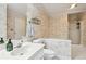Bathroom with toilet, sink, and soaking tub with shower. Features floral wallpaper and a towel rack at 4856 Saddlerun Ln, Powder Springs, GA 30127