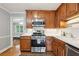 Well-lit kitchen features wood cabinetry, stainless steel appliances, and a modern gas range at 4856 Saddlerun Ln, Powder Springs, GA 30127